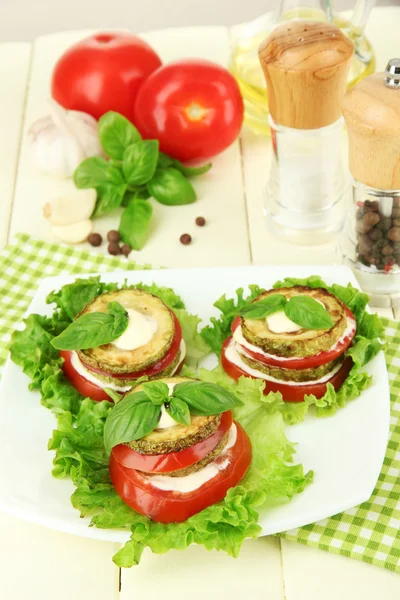 Sabroso tueste de médula y rodajas de tomate con hojas de ensalada, sobre fondo de madera — Foto de Stock