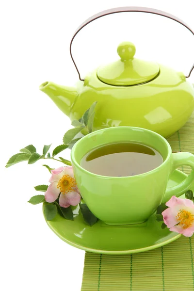 Tasse und Teekanne Kräutertee mit hippen Rosenblüten, isoliert auf weiß — Stockfoto