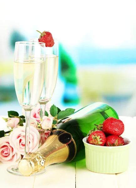 Romantische Stilleven met champagne, aardbei en roze rozen, op lichte achtergrond — Stockfoto