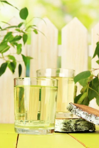 Glasses of birch sap on green wooden table — Stock Photo, Image