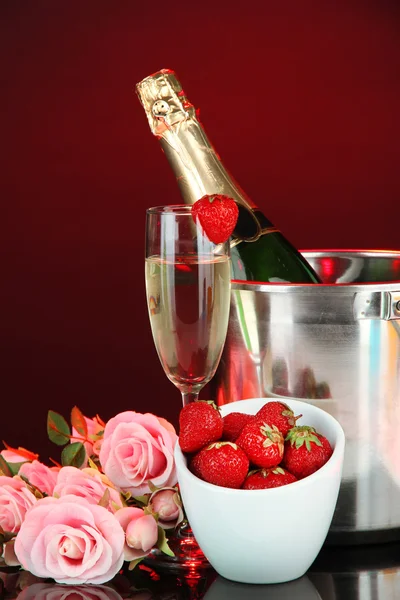 Romantic still life with champagne, strawberry and pink roses, on dark color background — Stock Photo, Image