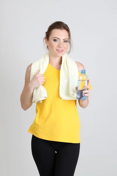 Mulher bonita com garrafa de água e toalha — Fotografia de Stock