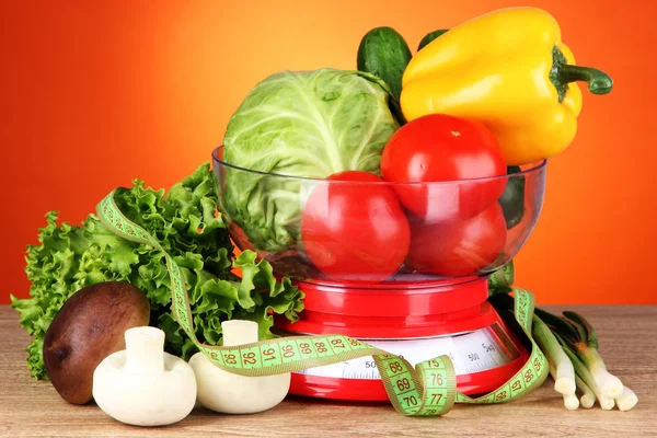 新鲜蔬菜在体重秤上橙色背景表格 — 图库照片