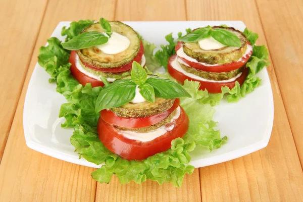 Sabroso tueste de médula y rodajas de tomate con hojas de ensalada, sobre fondo de madera —  Fotos de Stock