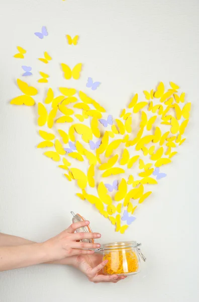 Paper yellow butterfly in form of heart fly out bank — Stock Photo, Image