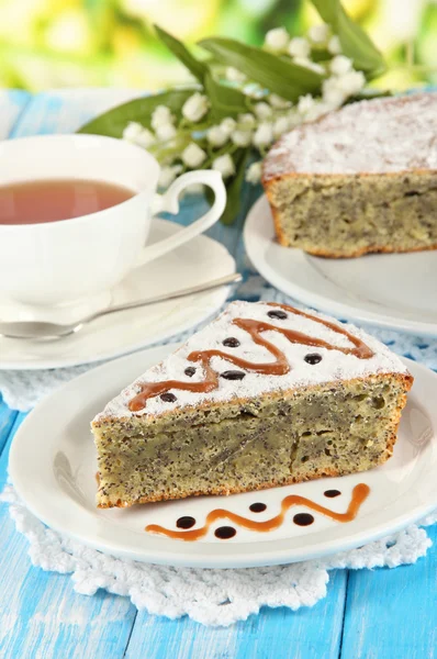 Delicious poppy seed cake with cup of tea on table on bright background — Stock Photo, Image