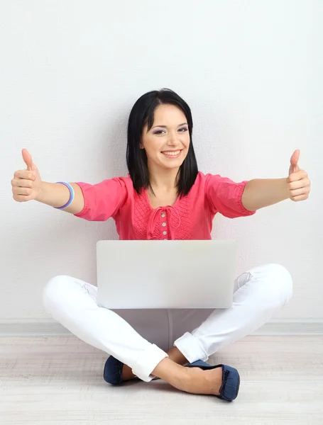 Hermosa joven sentada con cuaderno en la habitación — Foto de Stock