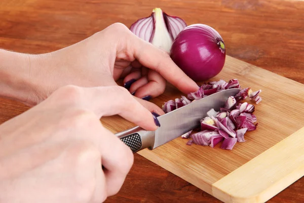 Cutting purple onion on wooden background