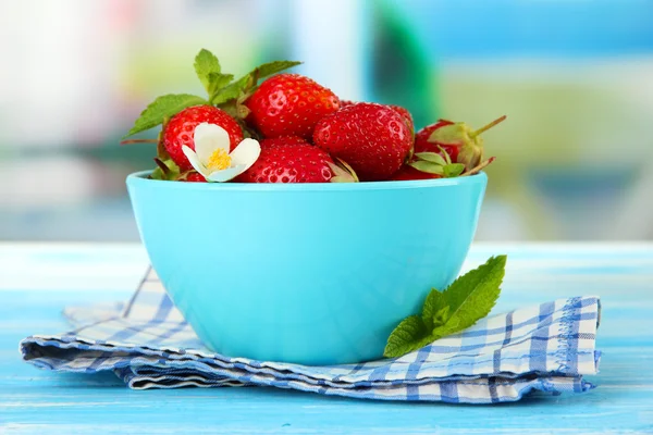 Rijpe zoete aardbeien in kom op blauwe houten tafel — Stockfoto