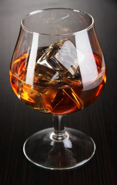 Vidrio de brandy con hielo sobre fondo de madera — Foto de Stock