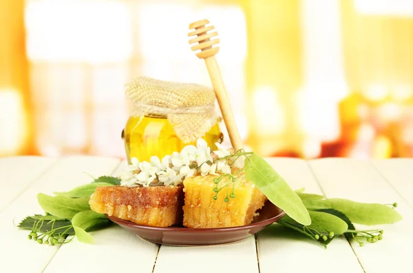 Jar of honey with flowers of lime, acacia on color wooden table on bright background — Stock Photo, Image