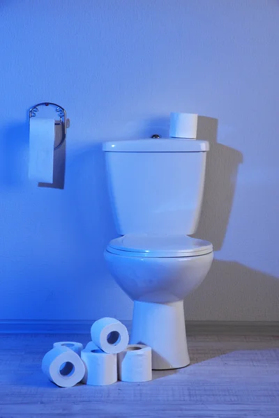 Tazón de inodoro y papel higiénico en un baño con luz azul —  Fotos de Stock