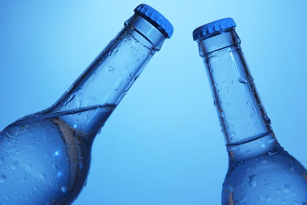 Бутылки с водой на голубом фоне — стоковое фото