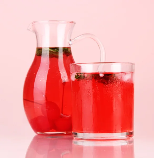 Cherry drink in pitcher and glass on red backgroun — Stock Photo, Image