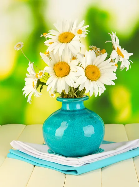 Beautiful bouquet chamomiles in vase on wooden table on natural background — Stock Photo, Image