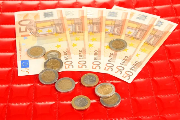 Banconote in euro e centesimi di euro su sfondo rosso — Foto Stock