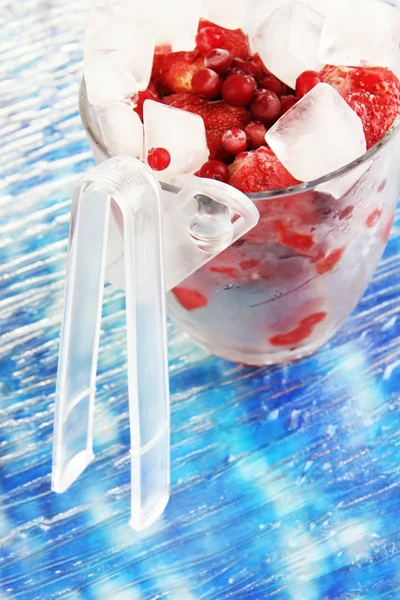 Frozen berries in bucket of ice on color background — Stock Photo, Image