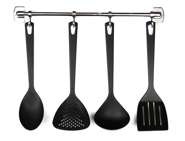 Utensílios de cozinha preto em ganchos de prata, isolado em branco — Fotografia de Stock