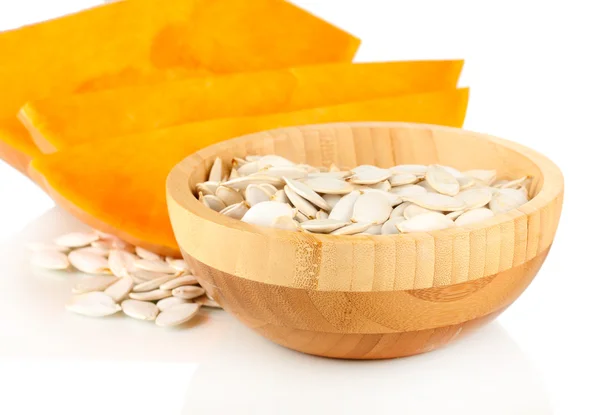 Pumpkin seeds in wooden bowl isolated on the white — Stock Photo, Image