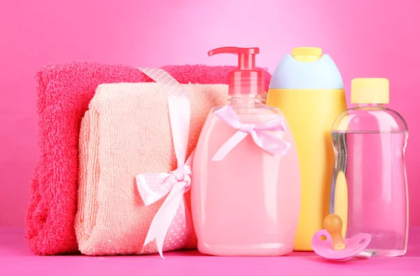 Baby cosmetics and towels on pink background — Stock Photo, Image