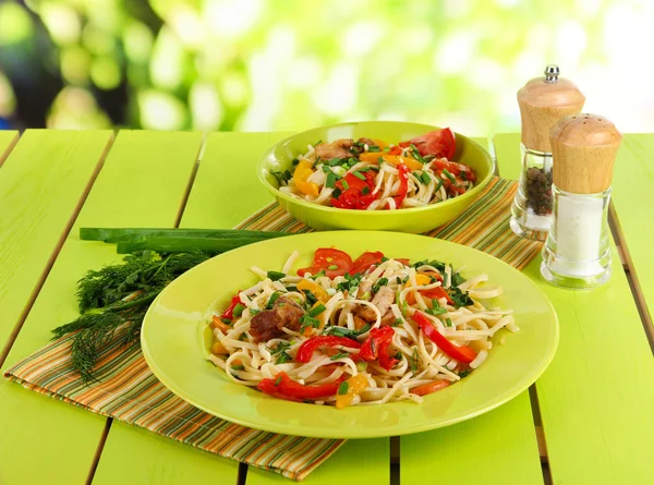 Noodles with vegetables on plates on nature background — Stock Photo, Image