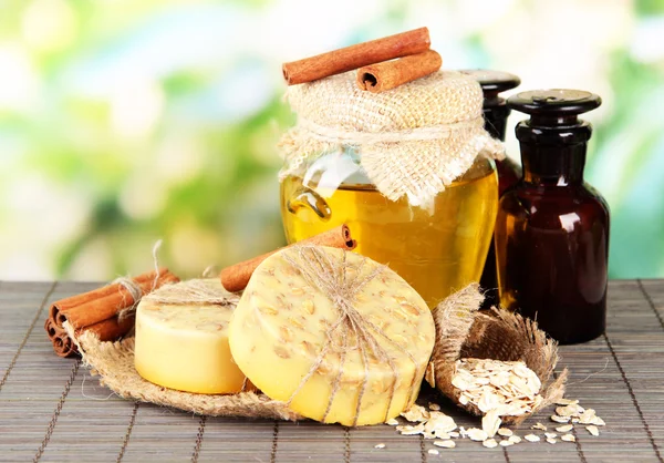 Handgemaakte zeep en ingrediënten voor zeep maken op bamboe mat, op groene achtergrond — Stockfoto