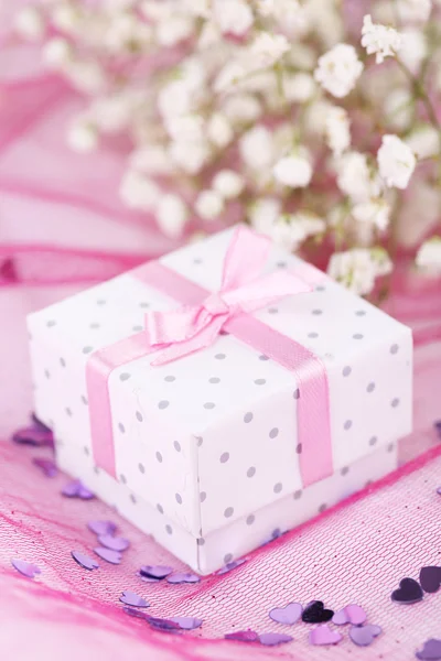 Flores y caja de regalo sobre fondo rosa — Foto de Stock