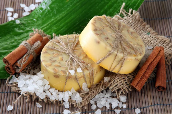 Sabão feito à mão, sal marinho e folha em esteira de bambu cinza — Fotografia de Stock