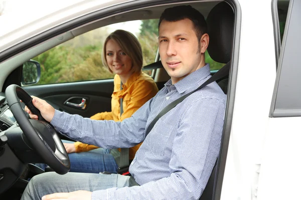 Retrato de jovem casal bonito sentado no carro — Fotografia de Stock