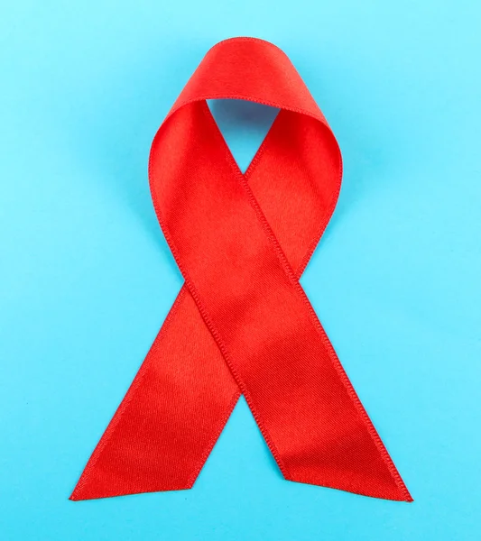Rött band hiv, aids på blå bakgrund — Stockfoto