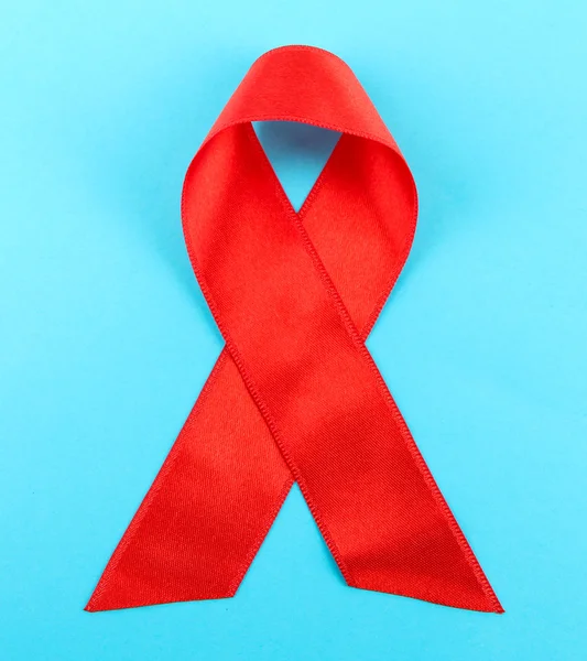 Red ribbon HIV, AIDS on blue background — Zdjęcie stockowe