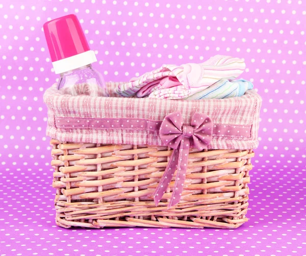 Beautiful basket of baby clothes on a pink background — Stock Photo, Image