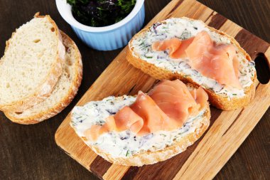 ahşap masa üzerinde kesme tahtası üzerinde balık sandviç