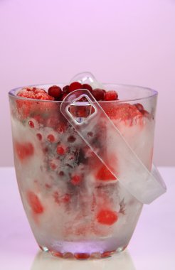 kova bir renk arka plan üzerinde buz dondurulmuş meyveler