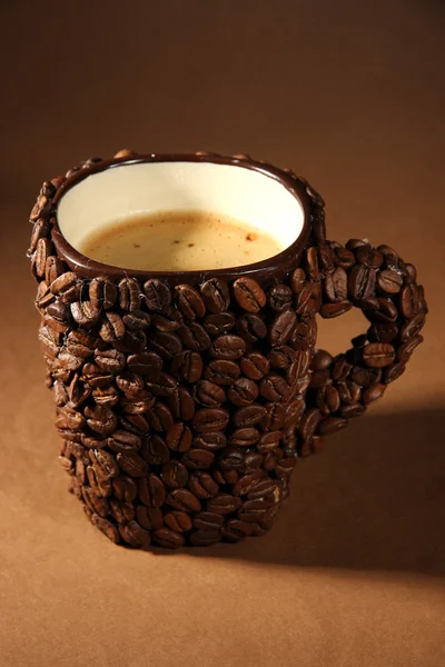 Pohár kávová zrna, na hnědé pozadí — Stock fotografie