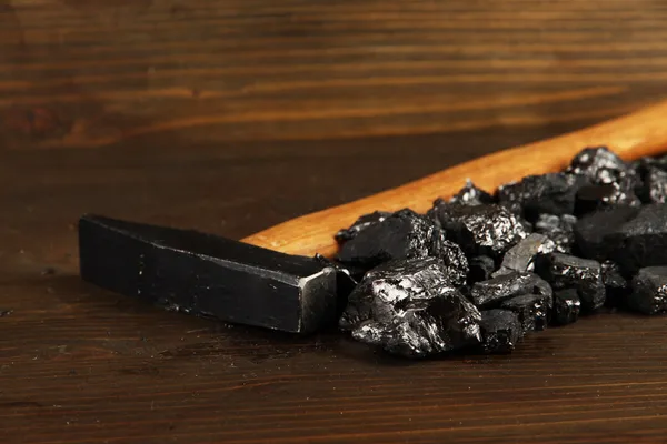 Уголь с хаммером на деревянном фоне — стоковое фото