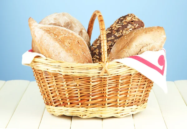 Composition with bread and rolls on wooden table, on color background — Stock Photo, Image