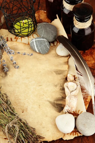 Composition with old papers, herbs, stones and bottles with symbols on wooden background — Stock Photo, Image