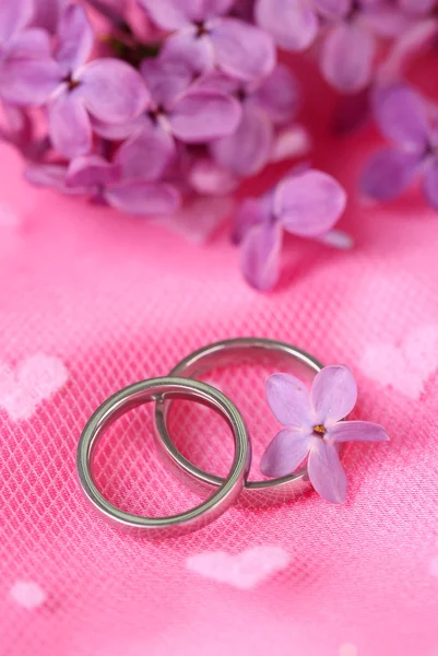 Красивые обручальные кольца на розовом фоне — стоковое фото
