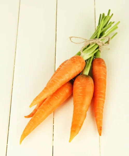 Un mucchio di carote su sfondo di legno di colore — Foto Stock