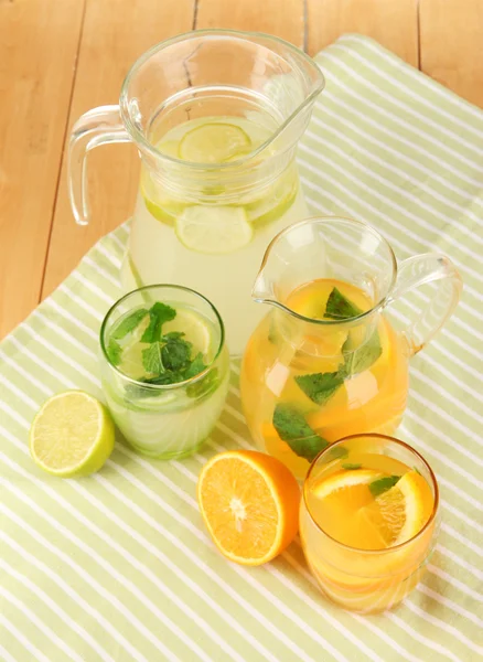 Sinaasappel- en citroenbomen limonade in werpers en bril op houten tafel close-up — Stockfoto