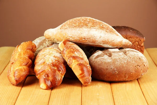 Samenstelling met brood en broodjes op houten tafel, op een achtergrond met kleur — Stockfoto