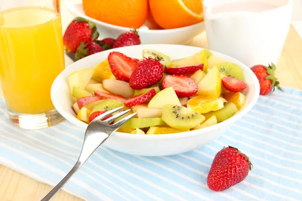 La ensalada útil de frutas frescas y las bayas en la escudilla a la servilleta a la mesa de madera el primer plano —  Fotos de Stock
