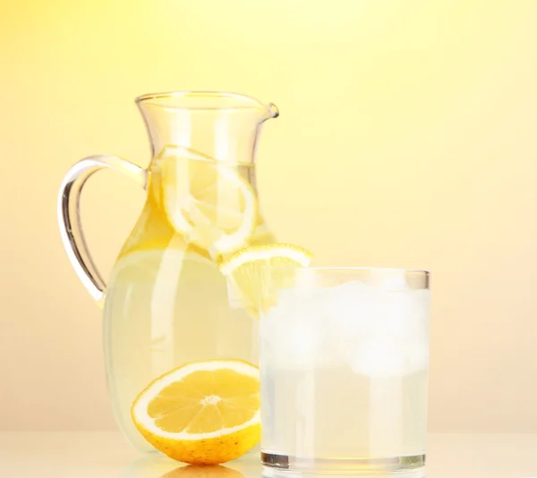 Limonada em jarro e vidro sobre fundo amarelo — Fotografia de Stock