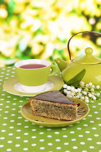 Delicious poppy seed cake with cup of tea on table on bright background — Stock Photo, Image