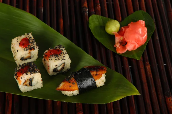 Sabroso sushi Maki - Roll on green leaf on bamboo mat —  Fotos de Stock