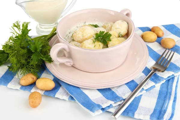 Las patatas tiernas jóvenes con la crema agria y las hierbas en la cacerola aislado sobre blanco — Foto de Stock