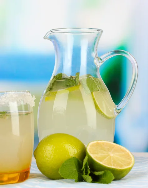 Citrus limonata in brocca e vetro su tavolo in legno su sfondo stanza — Foto Stock
