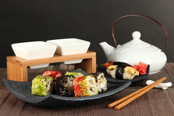 Leckeres Maki-Sushi - Rolle auf grünem Blatt auf Tisch auf grauem Hintergrund — Stockfoto