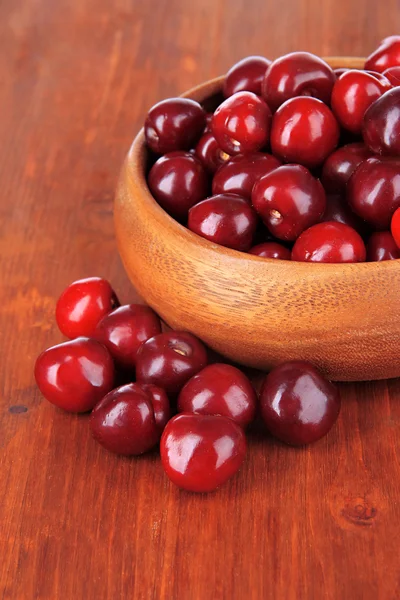 Cherry berries in bowl on wooden table close-up — Stock Photo, Image